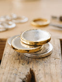 Macro of polished silver blanks with 18k gold dipped edges in champagne tones
